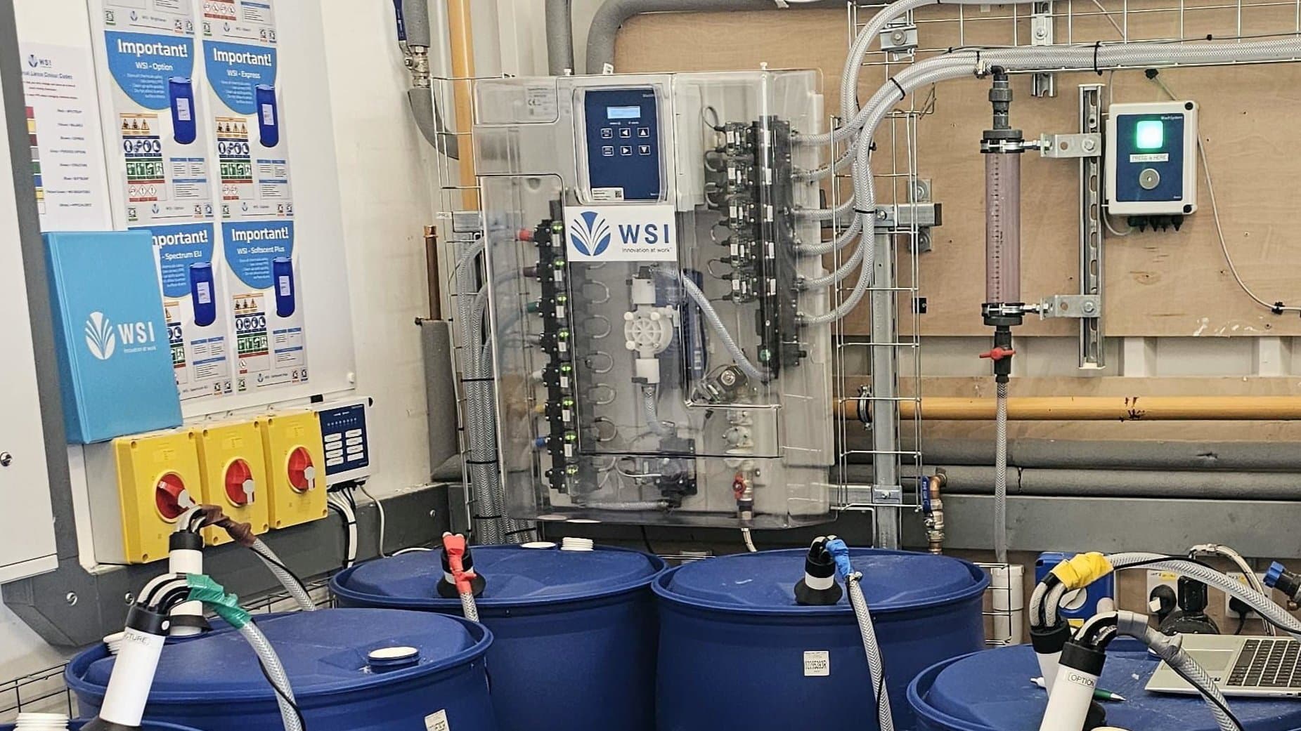 WSI chemical dosing panel with online monitoring installed above the chemical drums at Guest Linen